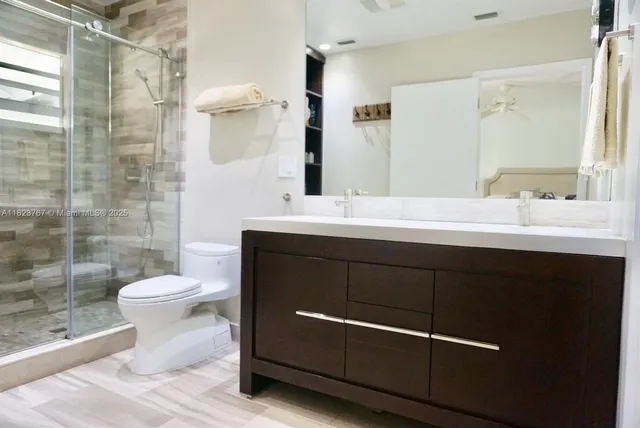 a bathroom with a sink a toilet and shower