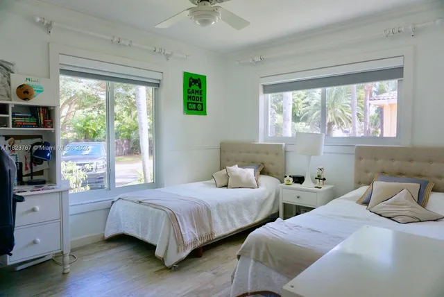 a bedroom with two beds and windows