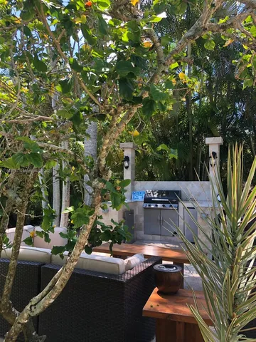 a view of a patio with table and chairs with a large tree