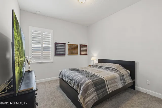 a bed sitting in a bedroom next to a window