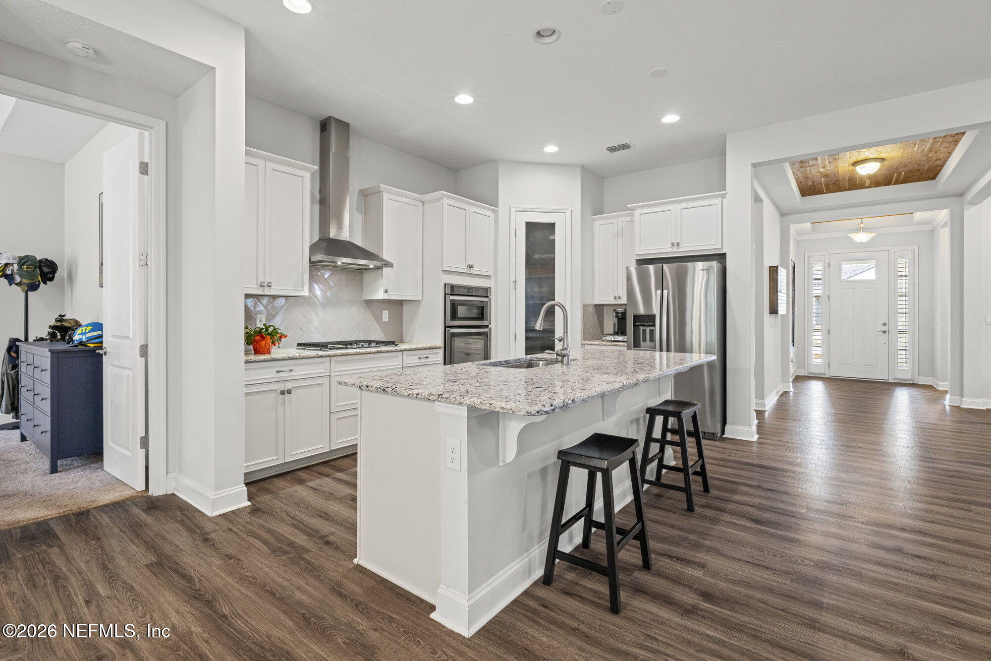87 Footbridge Road St. Johns, FL 32259 - Photo 7 of 32 a kitchen with stainless steel appliances kitchen island granite countertop a refrigerator a stove and white cabinets with wooden floor
