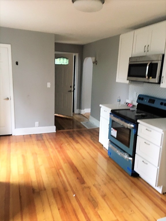 5 Mountfair Terrace Boston, MA 02136 - Photo 3 of 15 a kitchen with granite countertop a stove a sink and a microwave