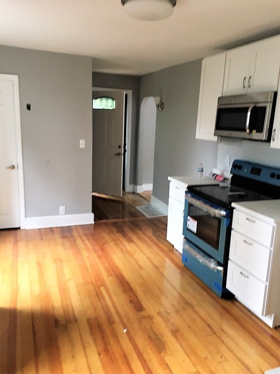 5 Mountfair Terrace Boston, MA 02136 - Photo 6 of 15 a kitchen with granite countertop a stove a sink and a microwave