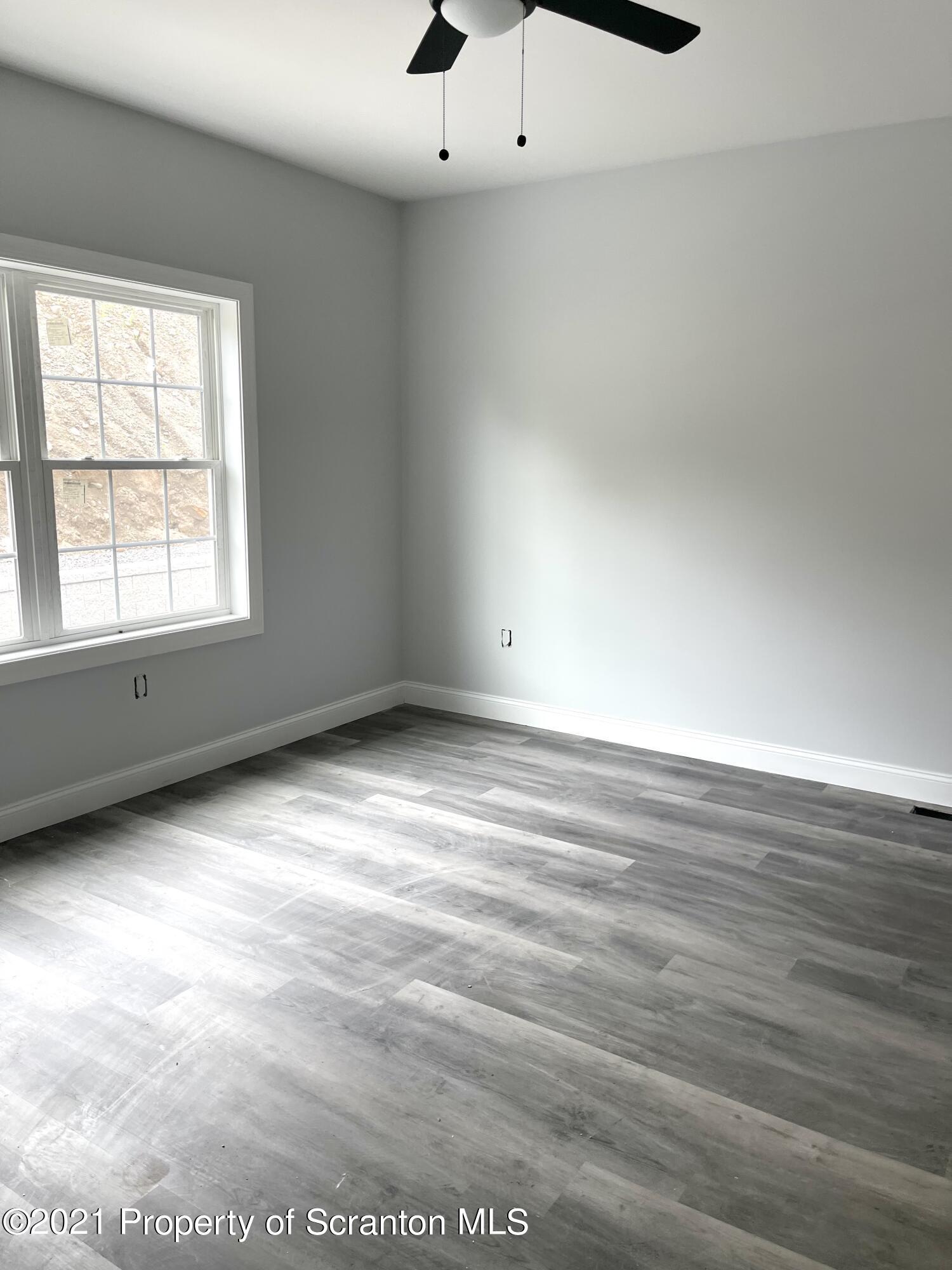 429 Felts Street Taylor, PA 18517 - Photo 11 of 13 an empty room with wooden floor and windows