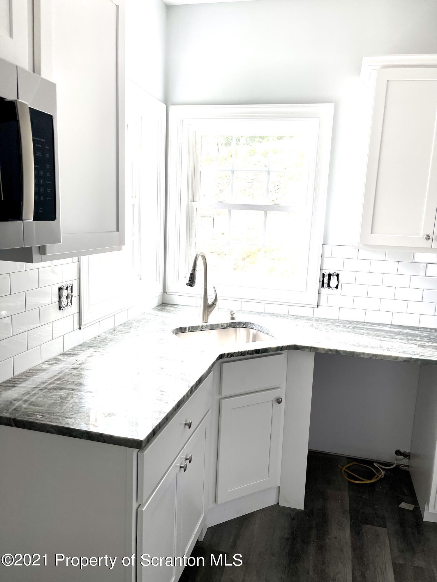 429 Felts Street Taylor, PA 18517 - Photo 4 of 13 a kitchen with a sink window and cabinets