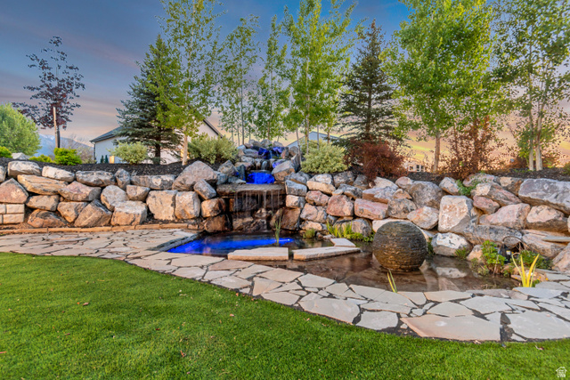 1526 South 500 West Mapleton, UT 84664 - Photo 22 of 54 Yard at dusk featuring a garden pond, a jacuzzi, and a lawn