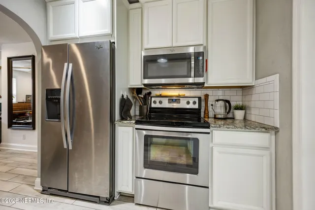 a kitchen with stainless steel appliances granite countertop a refrigerator stove and microwave