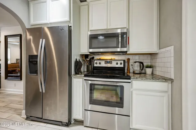 a kitchen with stainless steel appliances granite countertop a refrigerator stove and microwave