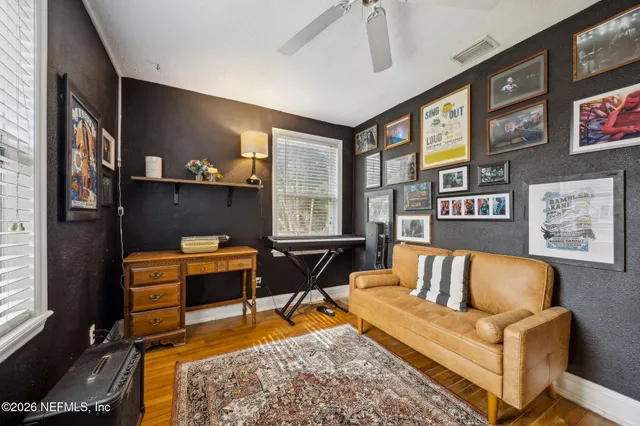 a living room with furniture a flat screen tv and next to a window