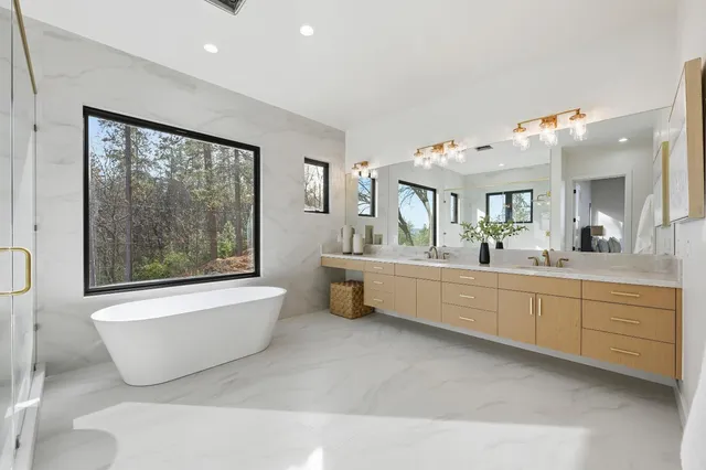 a bathroom with a double vanity sink toilet mirror and shower
