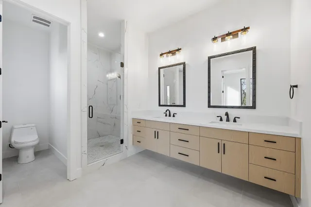 an aerial view of residential houses with outdoor space and trees