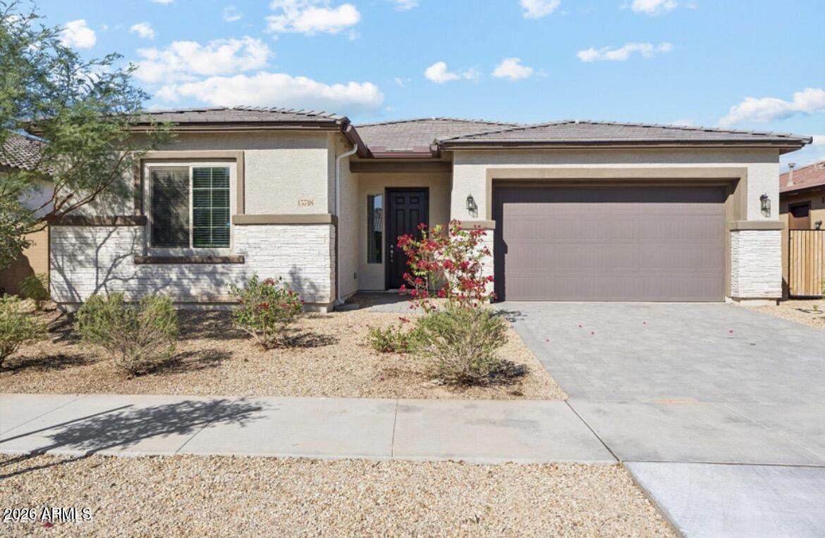 15718 West Adams Street Goodyear, AZ 85338 - Photo 1 of 6 a front view of a house with a yard and garage