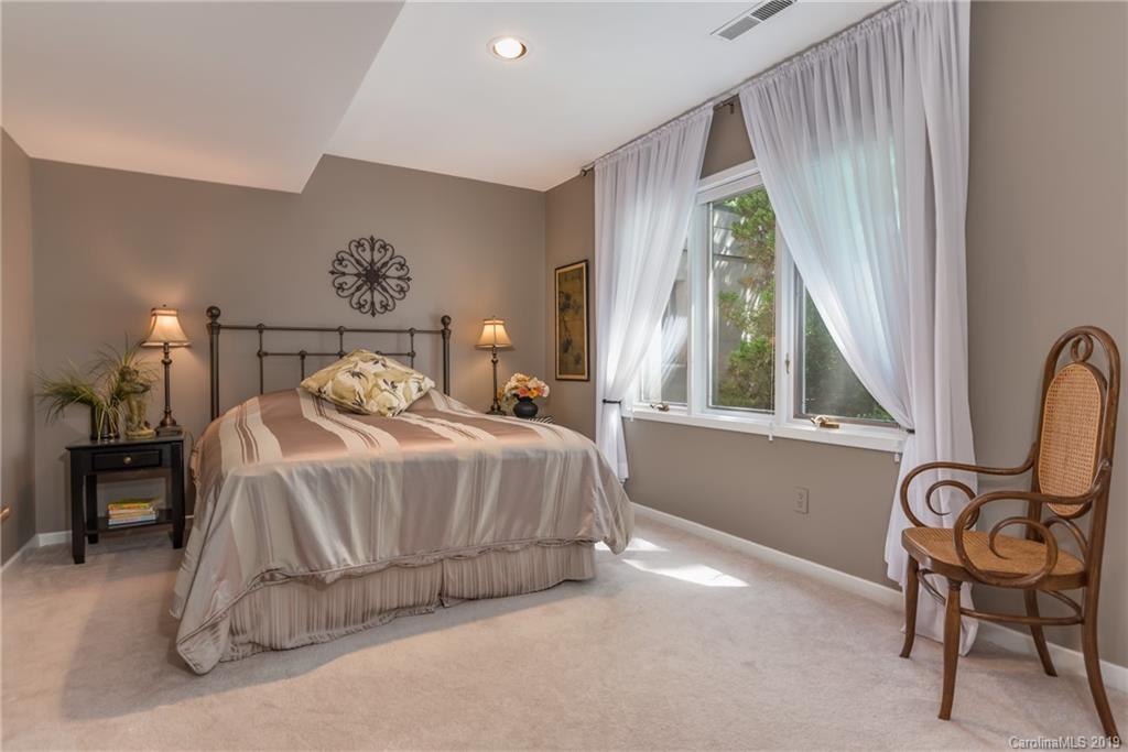 320 Ridgetop Road Tryon, NC 28782 - Photo 24 of 36 a bedroom with a bed and a chair