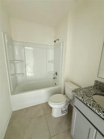 a bathroom with a granite countertop toilet a sink and a bathtub