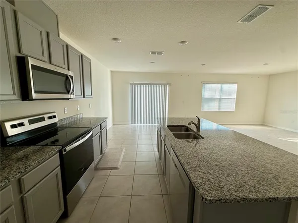 a kitchen with stainless steel appliances granite countertop a sink stove and microwave