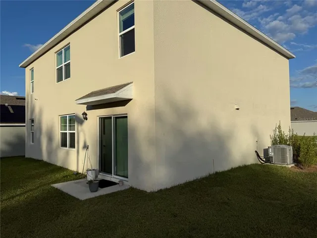 a backyard of a house with table and chairs