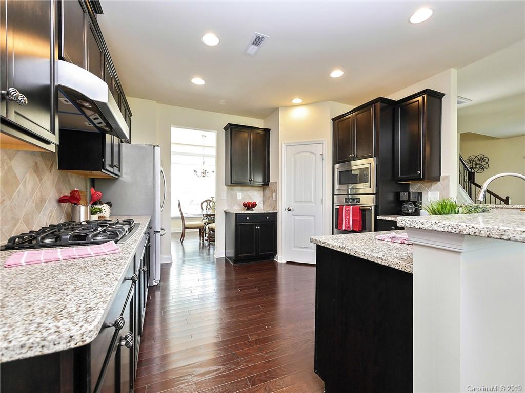 7817 Pope Farm Road Charlotte, NC 28269 - Photo 11 of 26 a kitchen with stainless steel appliances granite countertop a sink stove and refrigerator
