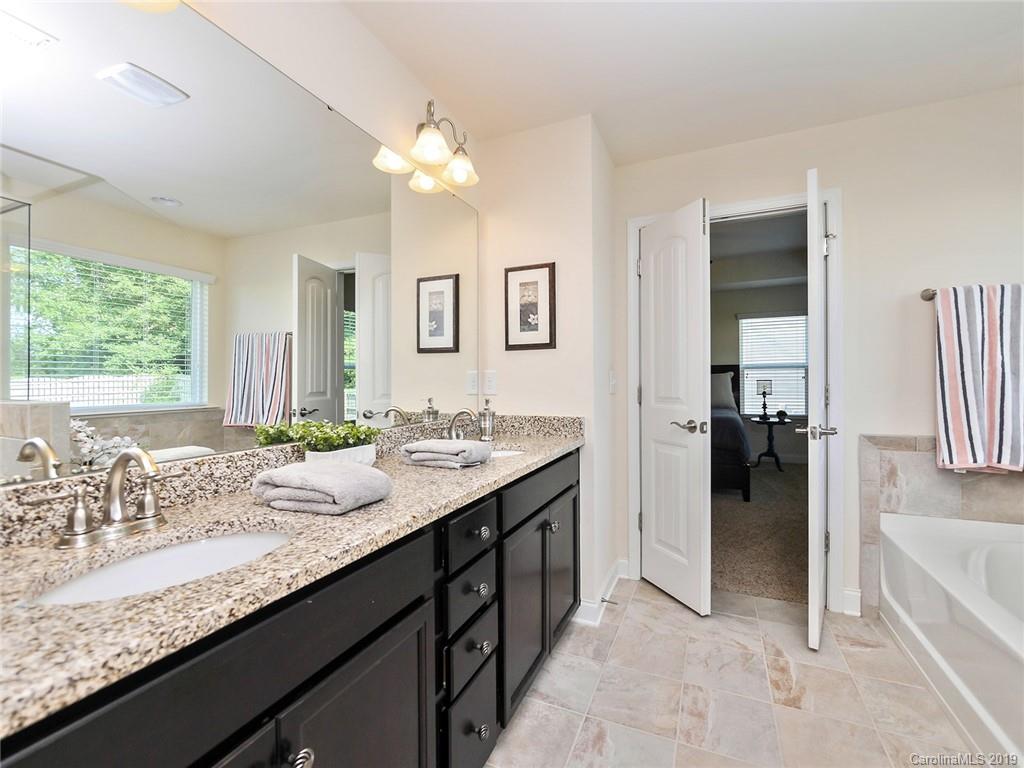 7817 Pope Farm Road Charlotte, NC 28269 - Photo 15 of 26 a en suite bathroom with a granite countertop sink and a mirror