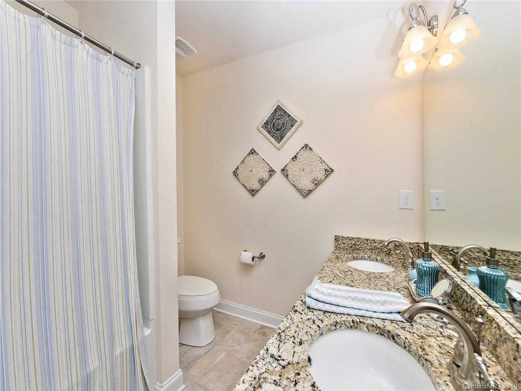7817 Pope Farm Road Charlotte, NC 28269 - Photo 18 of 26 a bathroom with a toilet a sink and mirror