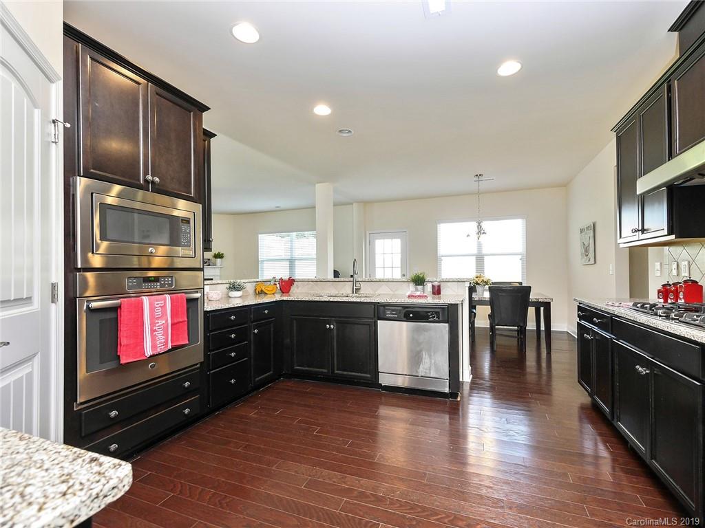 7817 Pope Farm Road Charlotte, NC 28269 - Photo 10 of 26 a kitchen with stainless steel appliances kitchen island granite countertop a refrigerator stove top oven and sink