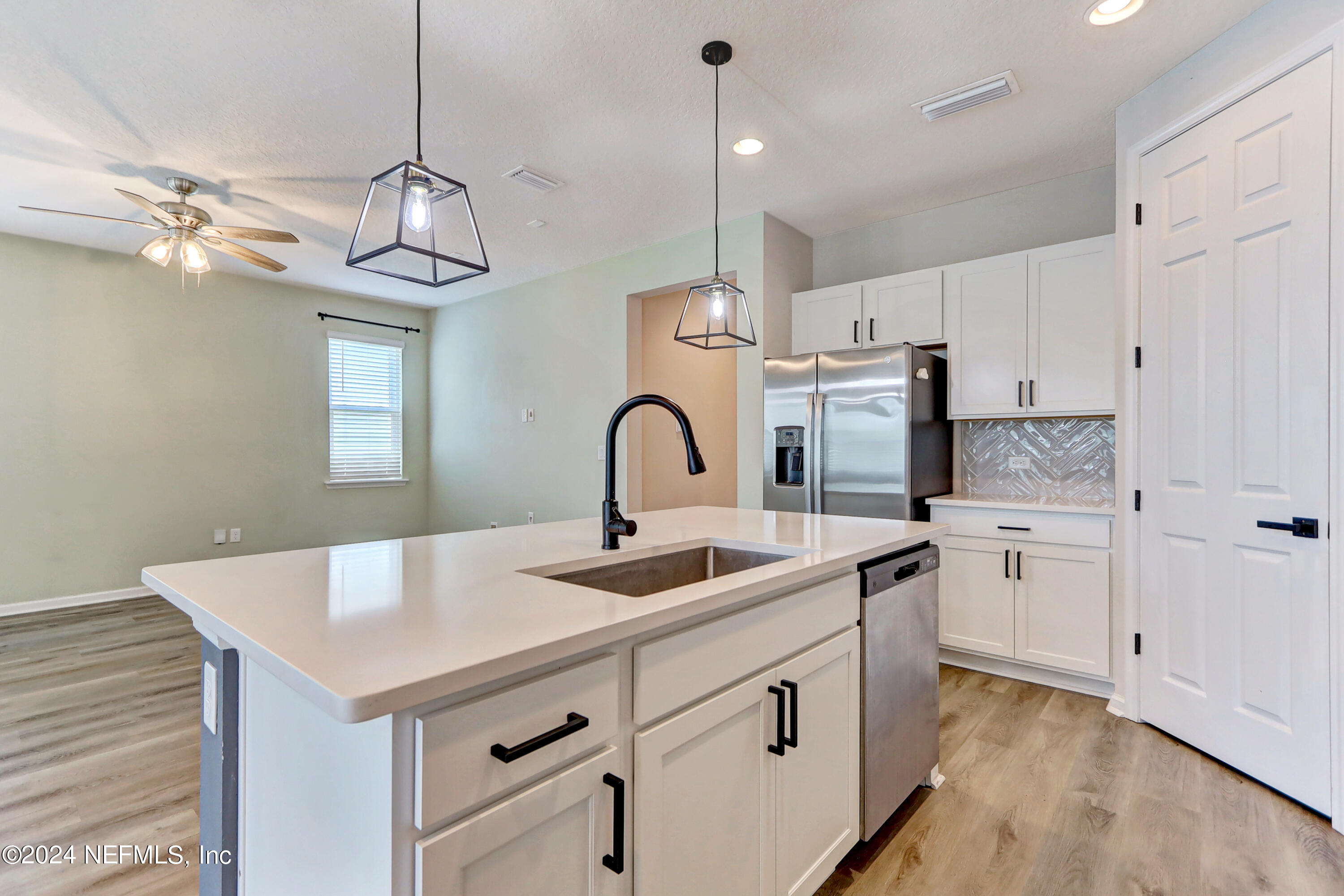 1880 Cogdill Trace Middleburg, FL 32068 - Photo 12 of 40 a kitchen with stainless steel appliances granite countertop a sink a stove a refrigerator and island with wooden floor