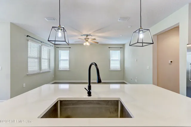 a kitchen with a sink a counter top space and a chandelier