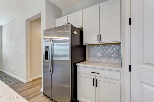 a kitchen with a refrigerator and cabinets