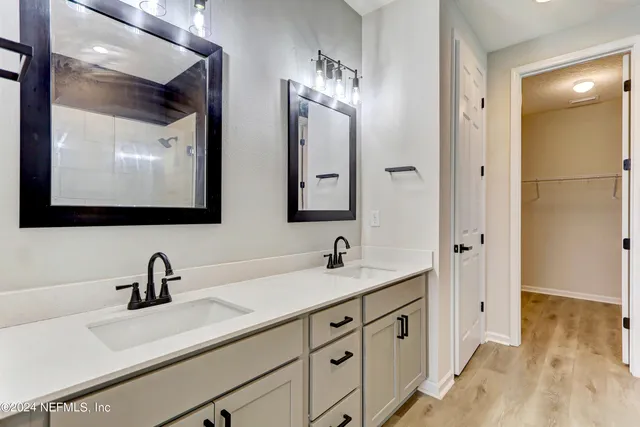 a bathroom with double sink and three mirror