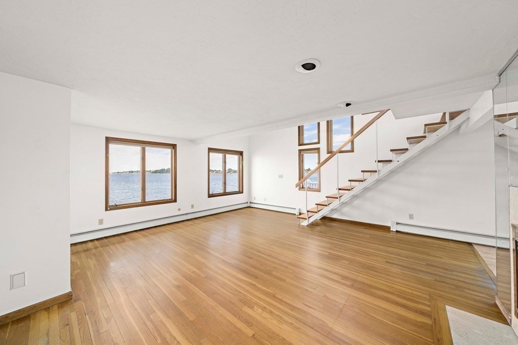 212 Nantasket Road Hull, MA 02045 - Photo 16 of 36 a view of an empty room with wooden floor and stairs