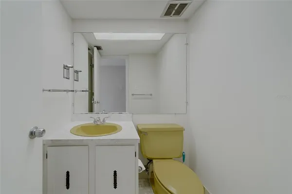a bathroom with a granite countertop toilet sink and mirror