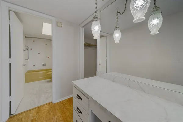 a bathroom with a sink a light fixture and a mirror