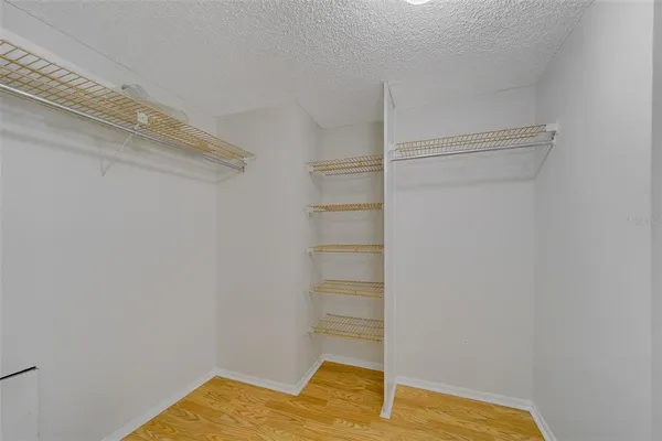 a view of walk in closet with empty racks