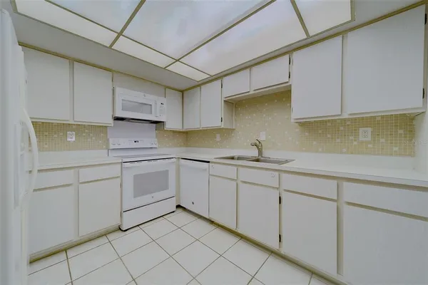 a kitchen with cabinets and white appliances