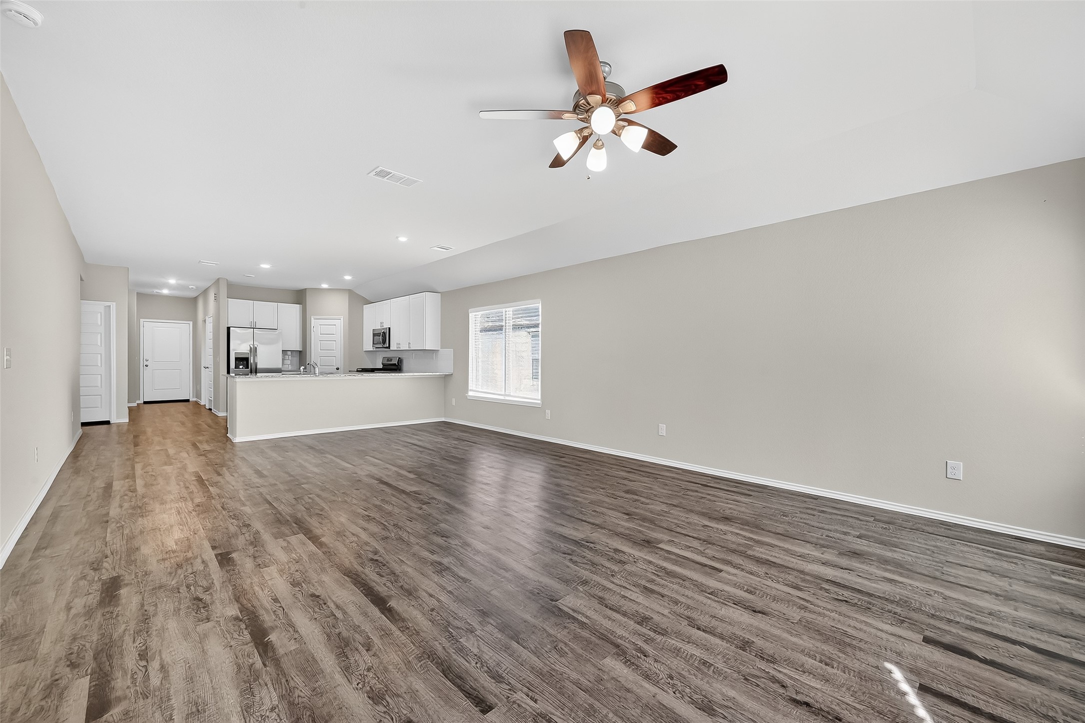 79 Courageous Way Magnolia, TX 77355 - Photo 11 of 23 a view of a kitchen with a sink and microwave with wooden floor