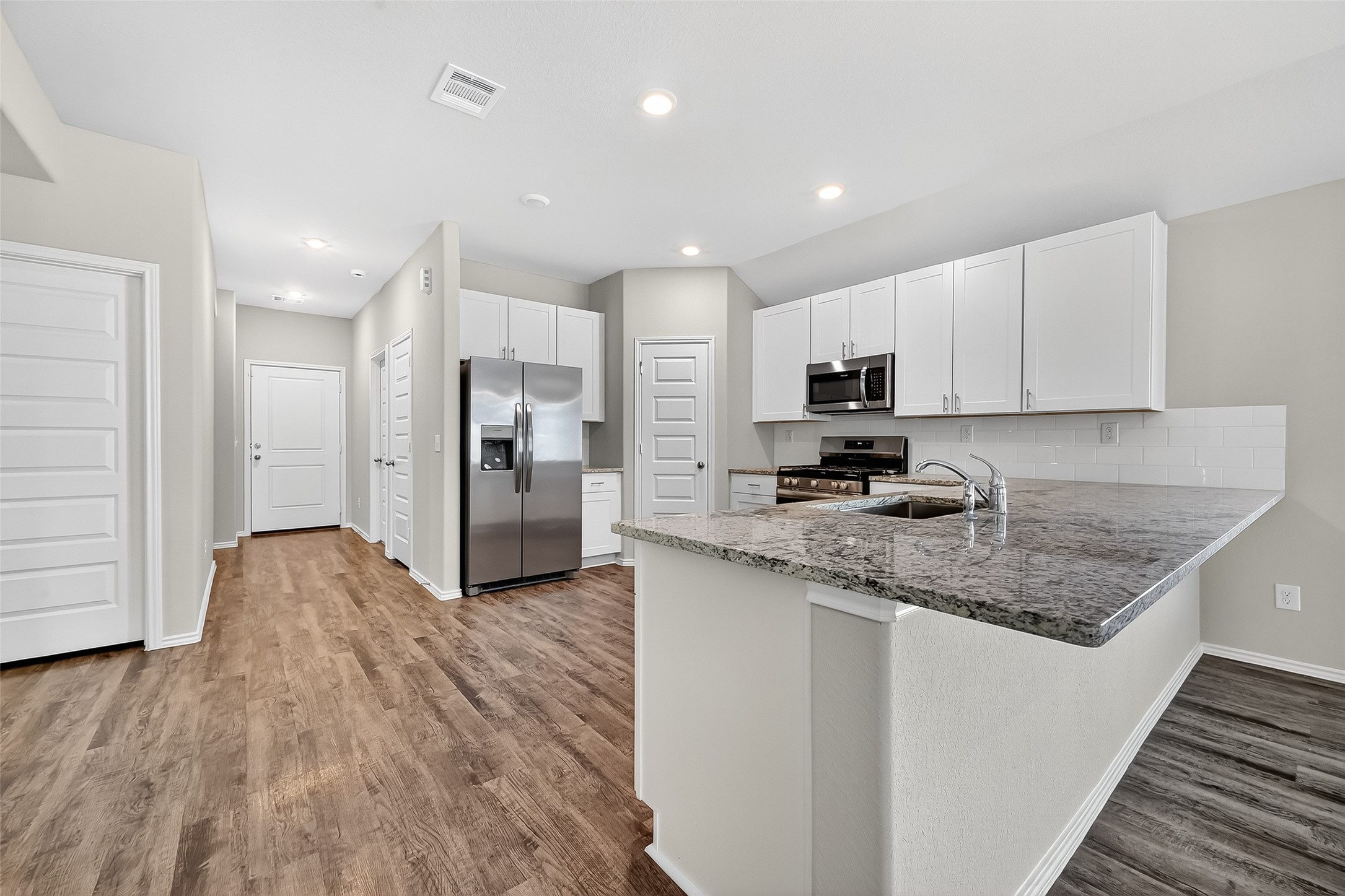 79 Courageous Way Magnolia, TX 77355 - Photo 4 of 23 a kitchen with stainless steel appliances granite countertop a stove a sink and a refrigerator