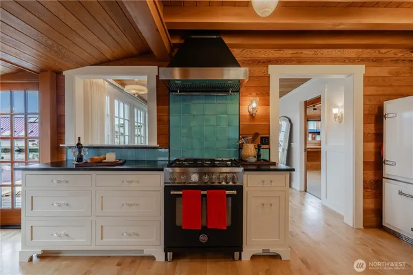 a kitchen with granite countertop a stove a cabinets and wooden floor