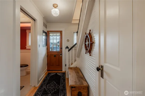 a view of a hallway with wooden floor and staircase