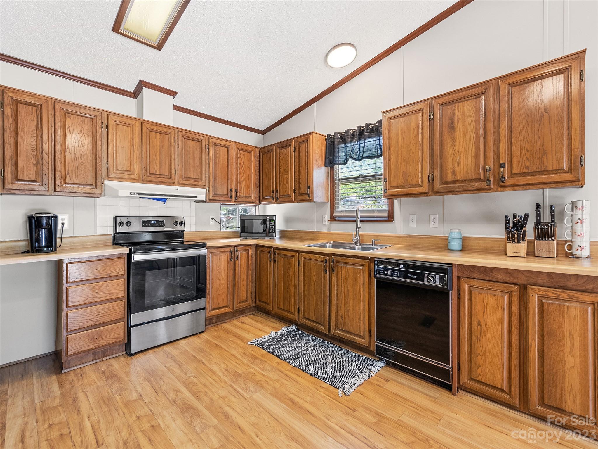 38 Happy Acres Road Waynesville, NC 28785 - Photo 17 of 28 a kitchen with stainless steel appliances granite countertop a stove a sink dishwasher and a refrigerator