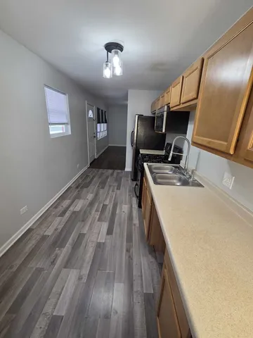 a kitchen with kitchen island wooden floor center island and stainless steel appliances