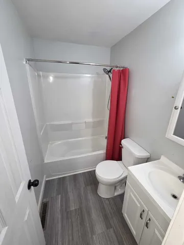 a white toilet sitting next to a bath tub and a shower