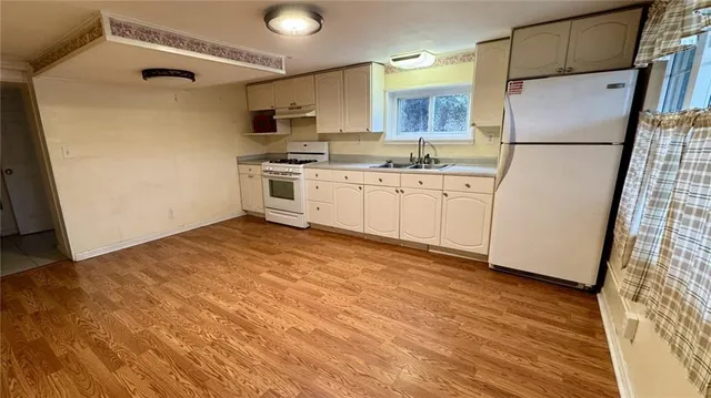 a kitchen with white cabinets and white appliances