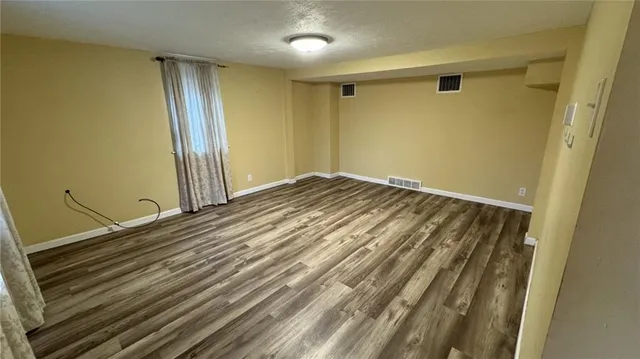 a view of a room with wooden floor