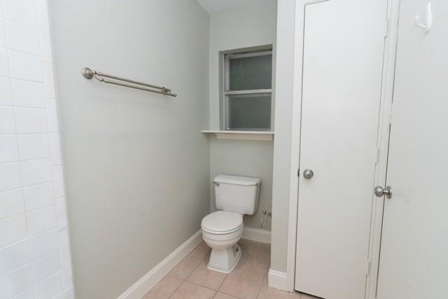 106 Mapleleaf Lane Coppell, TX 75019 - Photo 21 of 36 Bathroom featuring a white toilet, frosted window, light-toned wall paint, ceramic tile flooring, and white baseboards