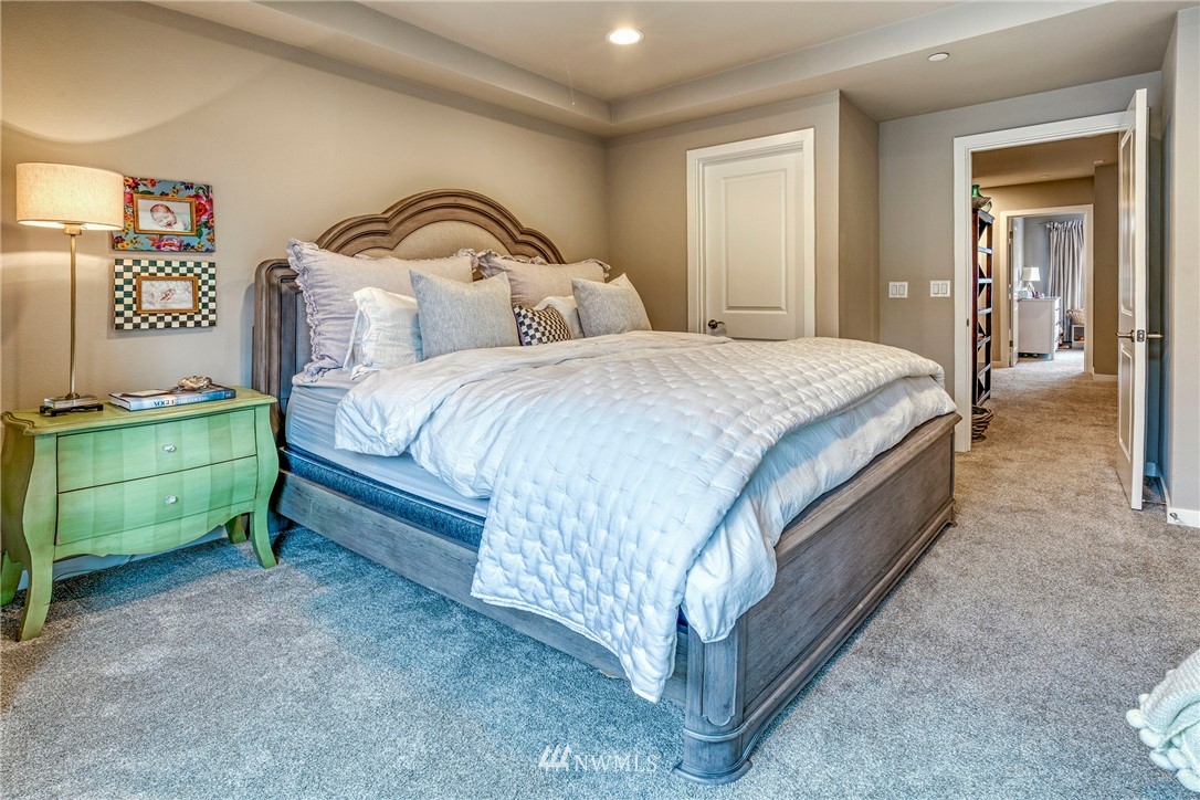 606 237th Street Southeast, Unit C Bothell, WA 98021 - Photo 16 of 27 a spacious bedroom with a bed and a lamp on the dresser