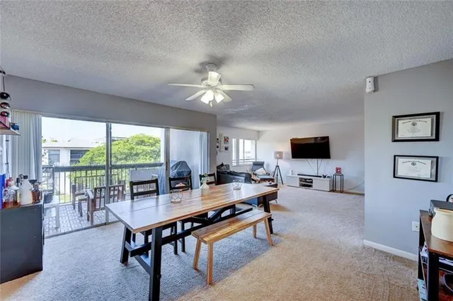 a living room with furniture a flat screen tv and a large window