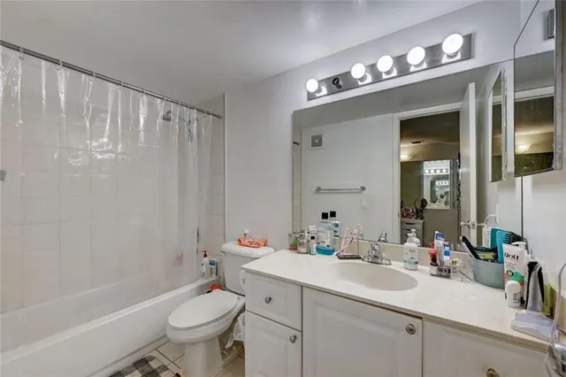a bathroom with a sink vanity mirror and toilet
