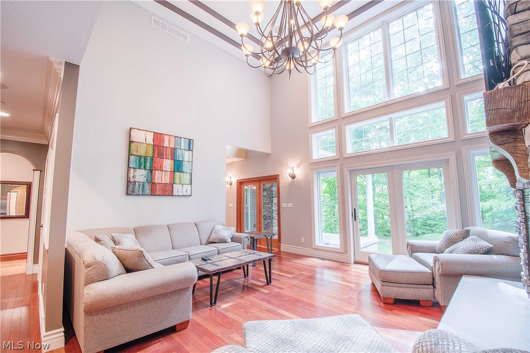 6868 River Styx Road Medina, OH 44256 - Photo 6 of 35 Great room w a wood-burning stone fireplace, 17' high ceiling, and a wall of windows w a perfect view of nature & access to the patio (w a stone fireplace).