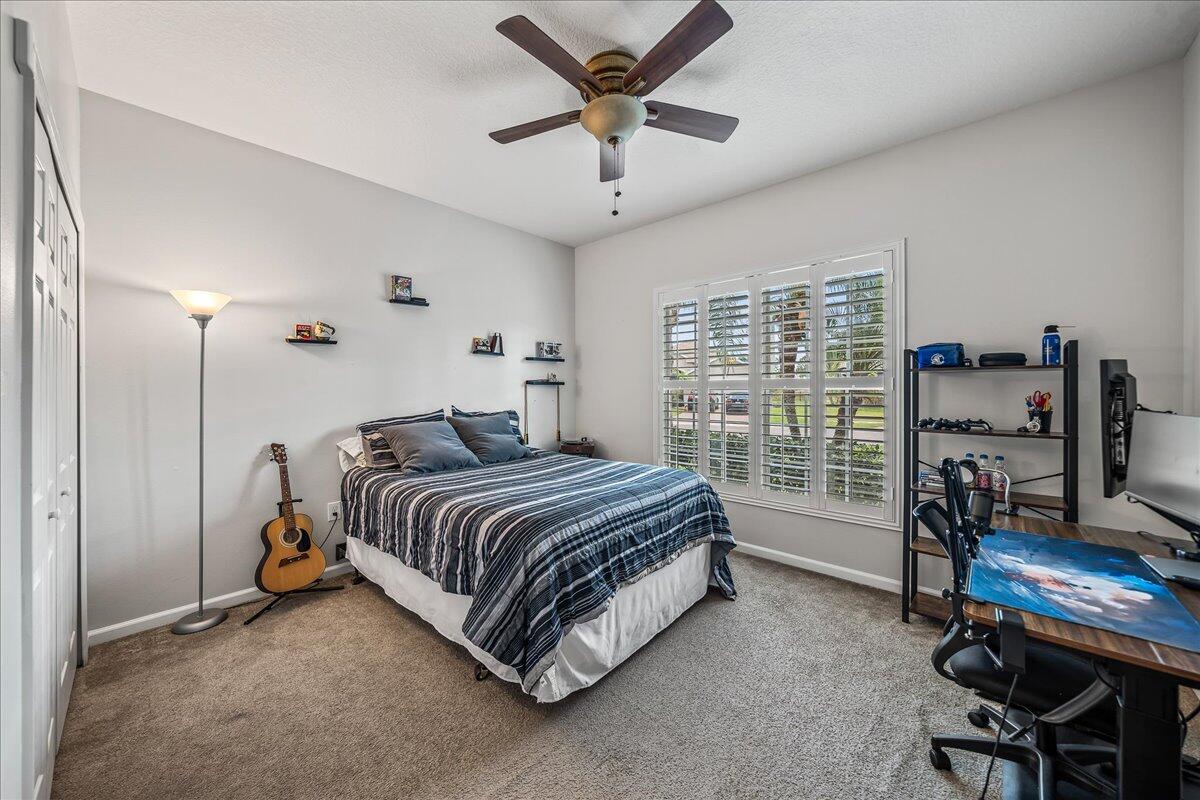 337 Abernathy Circle Palm Bay, FL 32909 - Photo 33 of 51 a spacious bedroom with a bed a desk and a chandelier