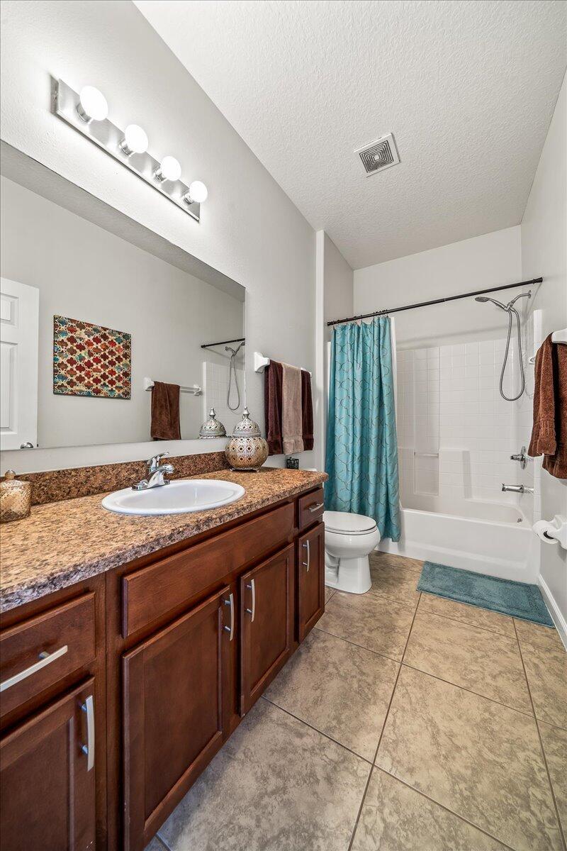 337 Abernathy Circle Palm Bay, FL 32909 - Photo 39 of 51 a bathroom with a granite countertop sink a toilet a mirror and shower