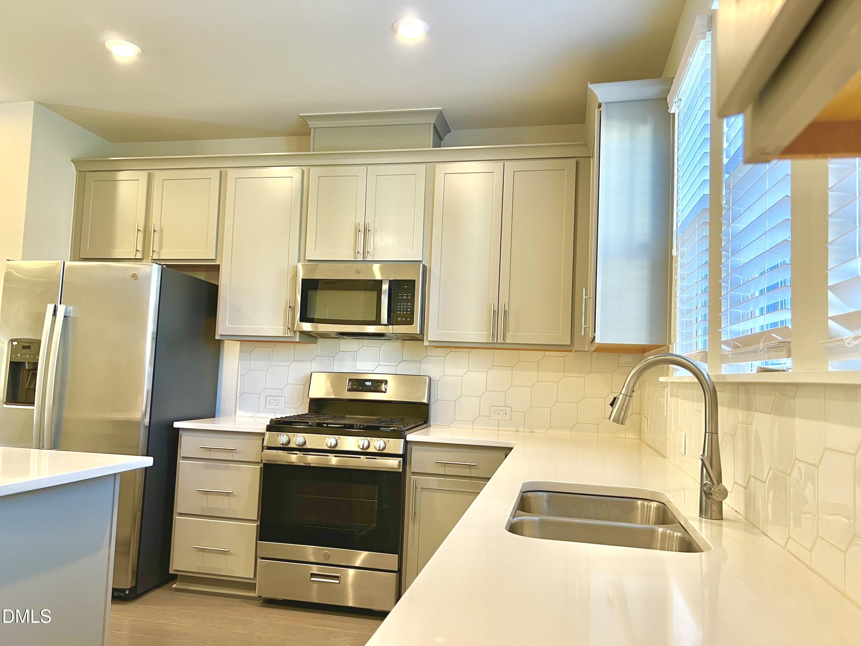 906 Waterside View Drive Raleigh, NC 27606 - Photo 7 of 9 a kitchen with stainless steel appliances granite countertop a stove a sink and a refrigerator